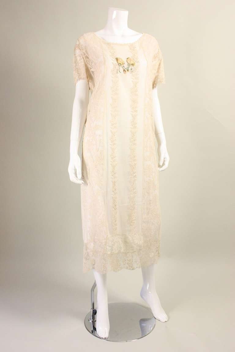 Vintage dress dates to the 1920's and is made of embroidered cream netting with filet lace inserts.  Center front ribbon rosettes at neckline.  Short sleeves and round neckline.  No closures.  Unlined.

No size label, but when looking at the