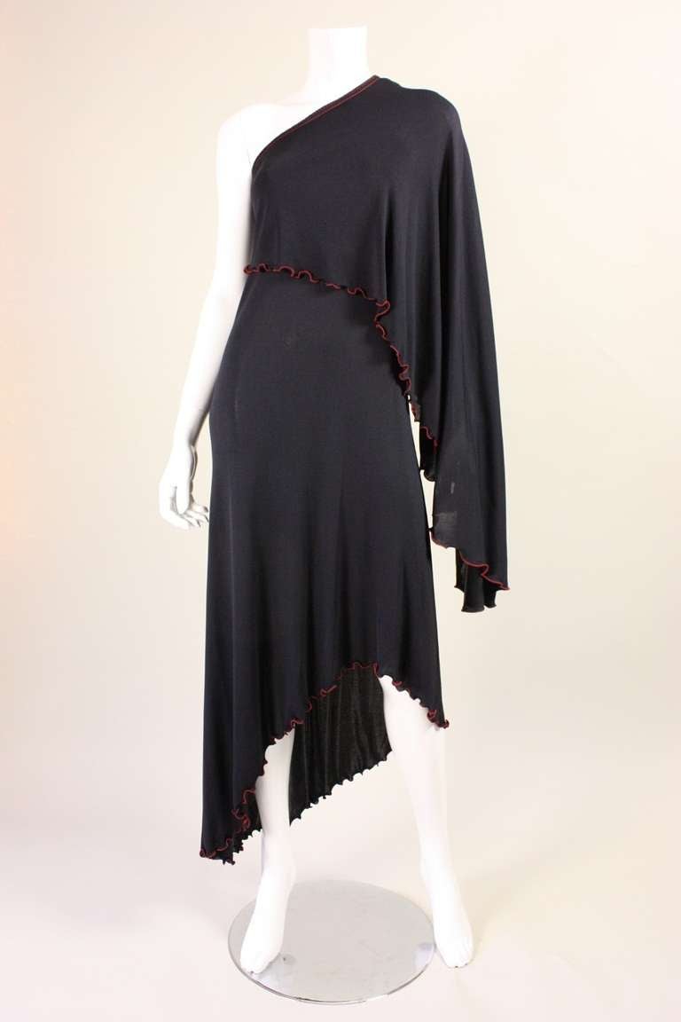 Vintage dress from Stephen Burrows dates to the 1970's and is made of black matte jersey with his signature red zigzag stitching at the edges.  One-shouldered.  No closures and unlined.

No size label, but we estimate it to fit a size