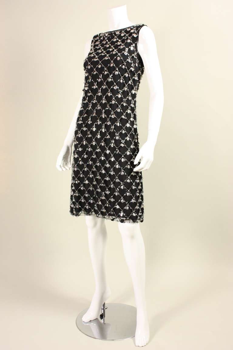 Vintage dress dates to the 1960's and features beading and paillettes in a crisscrossed pattern.  It is made of black netting with a black silk backing.  Round neck.  Sleeveless.  Center back zipper.  There is no label present; however, I have seen