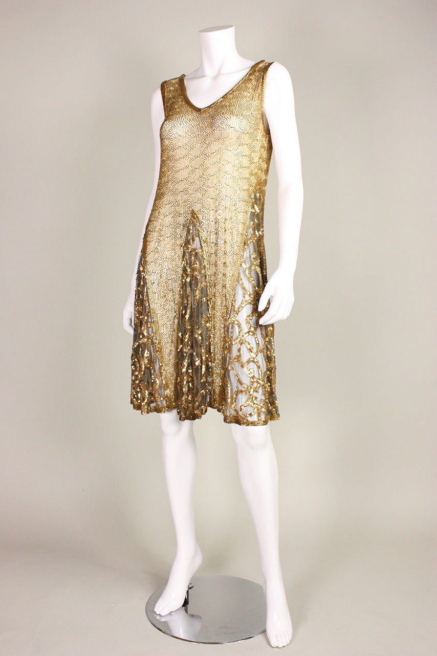 Vintage dress dates to the Art Deco era during the Roaring 1920's.  It is made of soft sheer netting that is covered with gold bugle beads arranged in a geometric pattern.  Godets in skirt have scrolling bands of gold sequins.  Unlined.  No