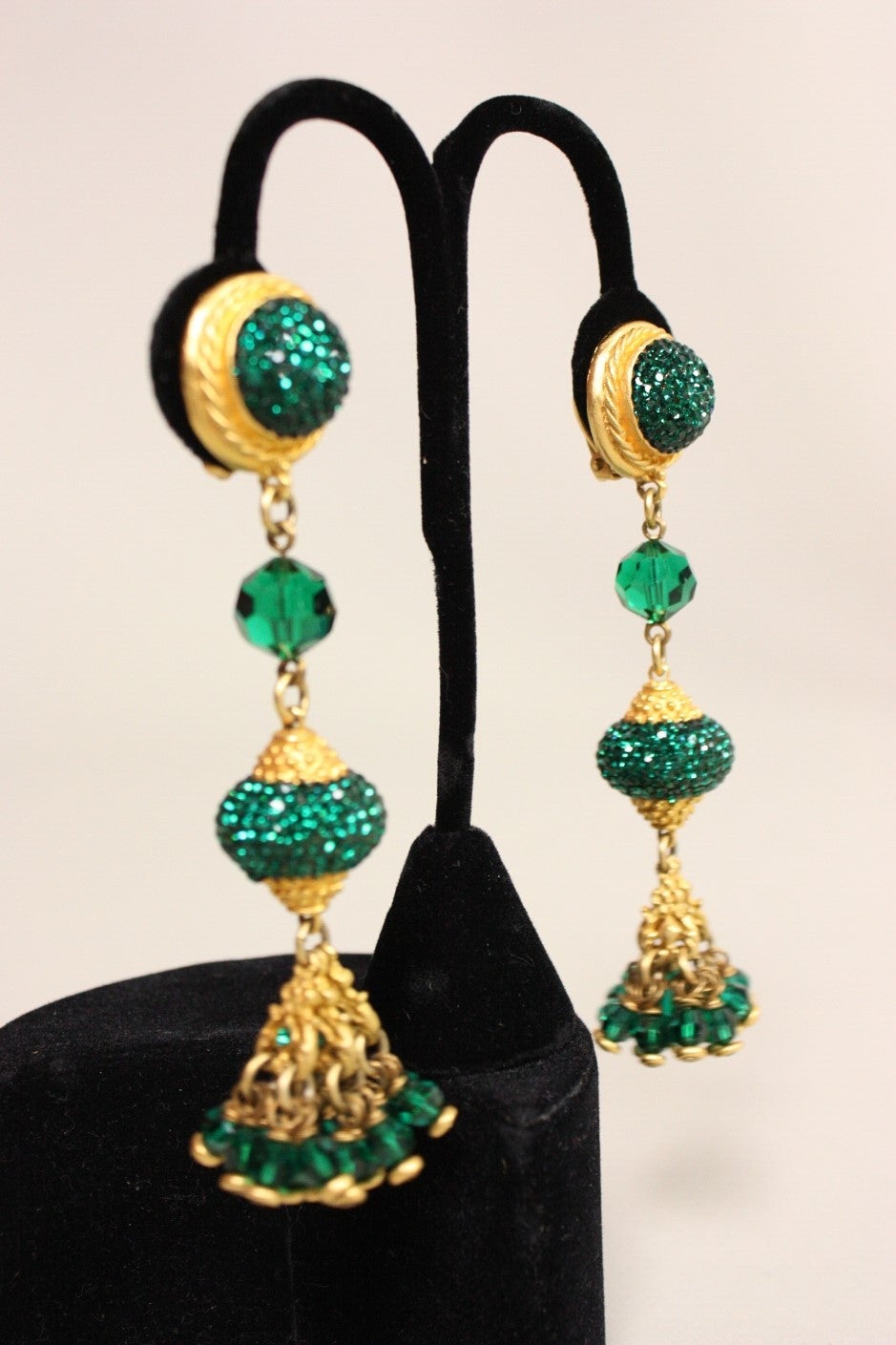 Gold-toned earrings from Los Angeles-based designer Deanna Hamro likely date to the 1990's.  They feature pave set emerald green crystals and faceted glass beads of the same color.  Clip backs.