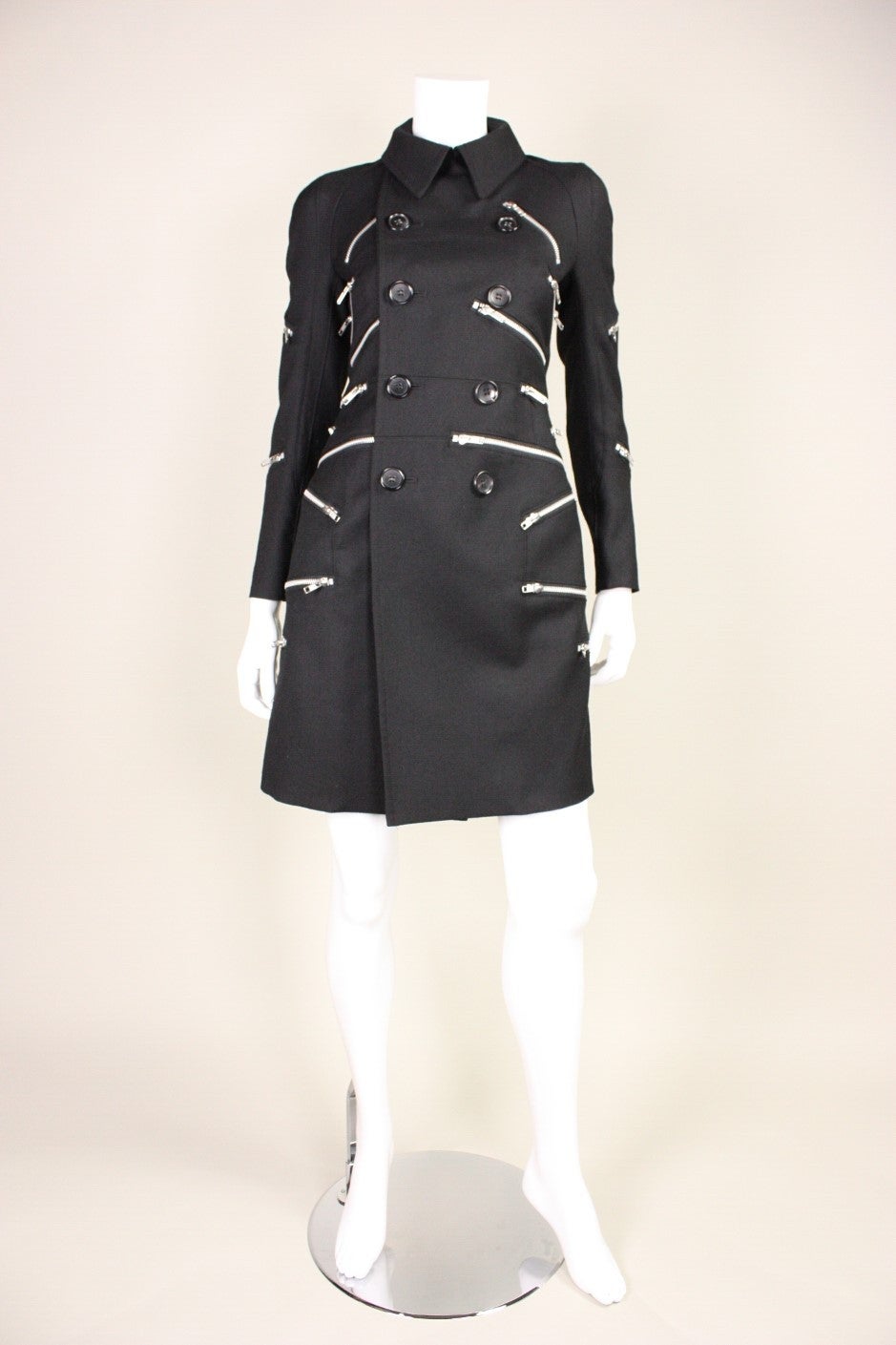 Contemporary coat from Comme des Garçons from the 2013 collection is made of black wool with silver-toned zippers.  Fitted throughout.  Fully lined.  Button closures.

Labeled size small.

Measurements - 

Bust: 32"
Waist: