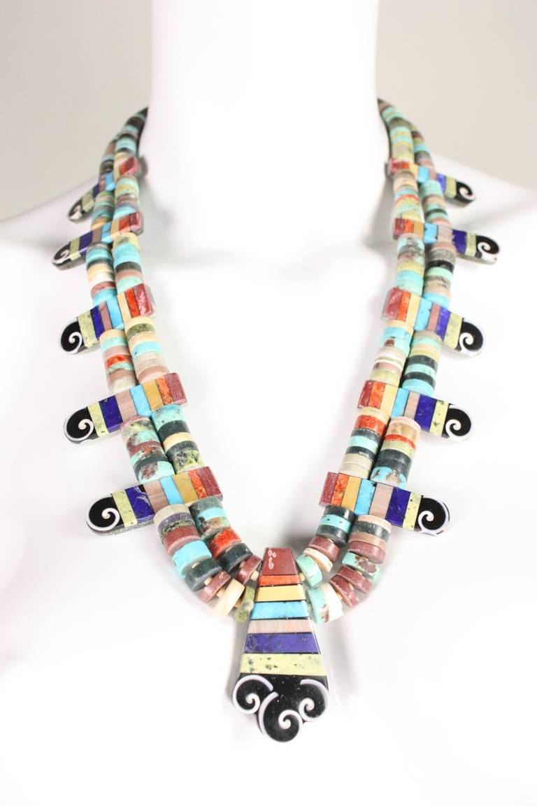 Mary and Lorenzo Tafoya contemporary necklace is made of a variety of inlaid semi-precious stones including turquoise. Intricate and rare piece.  The artists are of the Santo Domingo pueblo.  

Length: 14.5-17"