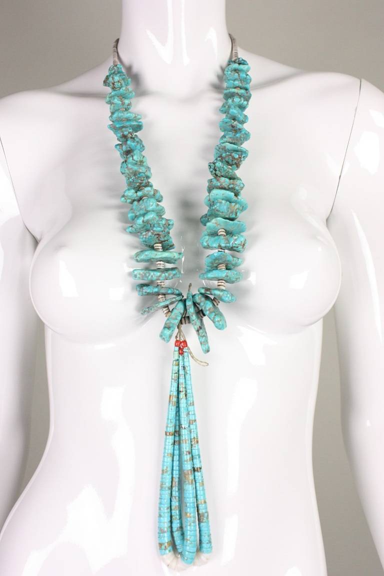 Vintage necklace by Native American artist Joe Garcia dates to the 1970's.  It is jacla style, having a second tier of necklaces hanging down from the main necklace.  It features large turquoise nuggets with shell heishi in between.  Silver clasp. 