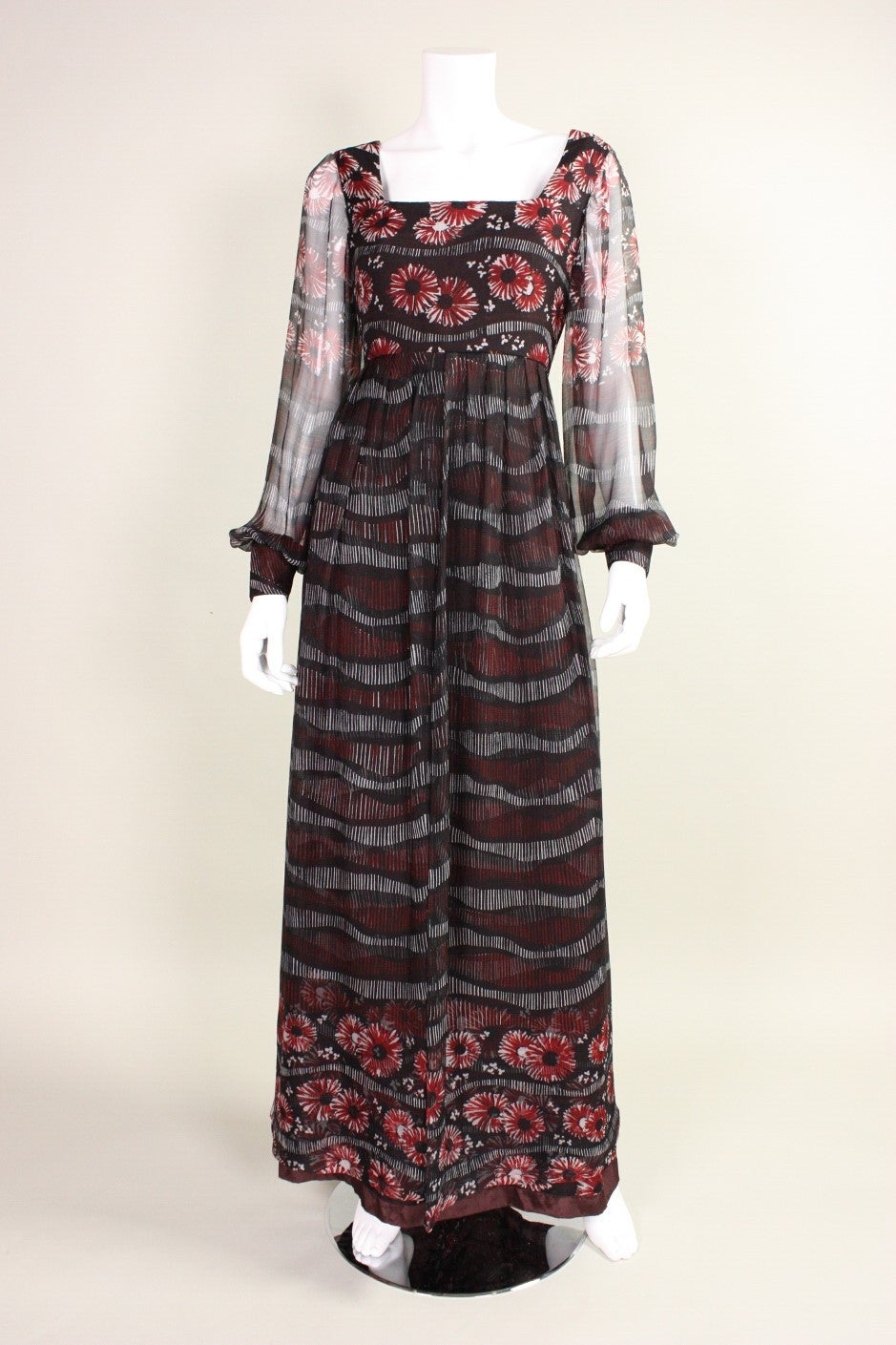 Vintage Vera Hicks maxi dress dates to the 1970's is made of black silk chiffon with a floral print.  Long sheer sleeves have fitted cuffs with snap closures.  Ankle length skirt has chiffon over layer  that is gathered all around waistband and is