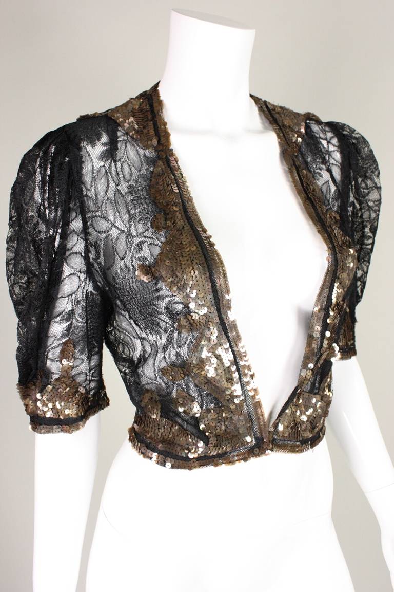 Black lace bolero dates to the 1930's is is trimmed with copper colored sequins.  Short sleeves.  Unlined.  Center front hook and eye closure.