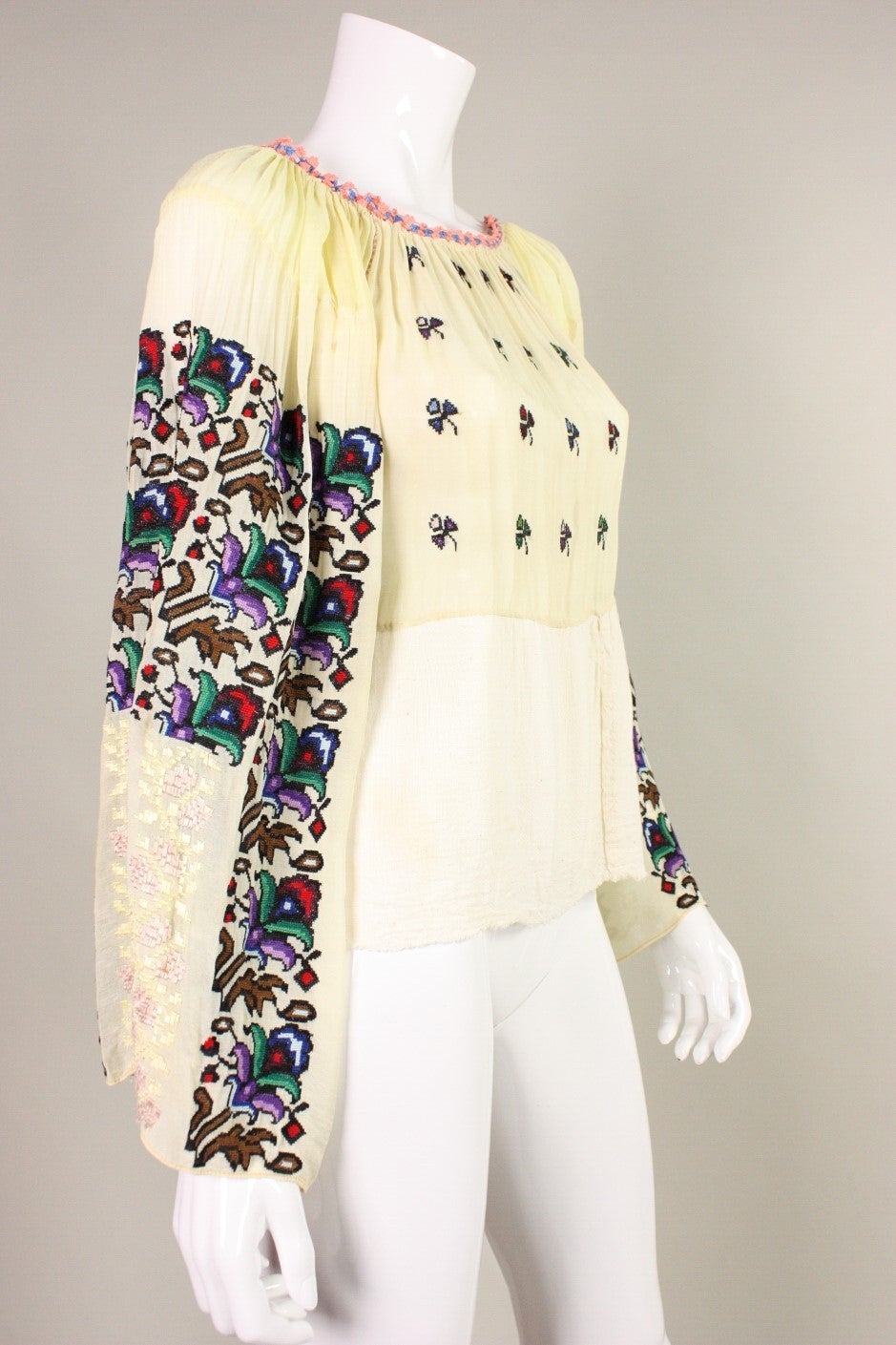 Museum-quality 1930's Eastern European blouse has bold, floral hand-embroidery down the sleeves and on the front of the blouse. Made of a cream-colored cotton gauze. Wide band of muslin was added to hem around the time it was made or soon after. 