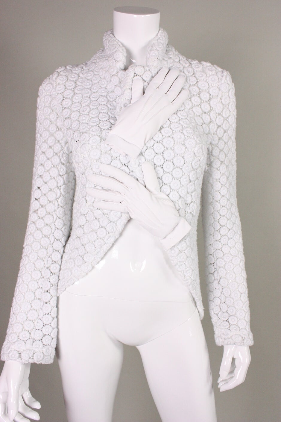 Amazing sweater from Comme des Garçons circa 2007 is made of a white open weave knit.  It features padded hands crossing over the front of the chest.  Stand collar.  Cutaway front.  Center back vent.  Unlined.  No closures.

Labeled a size Medium.