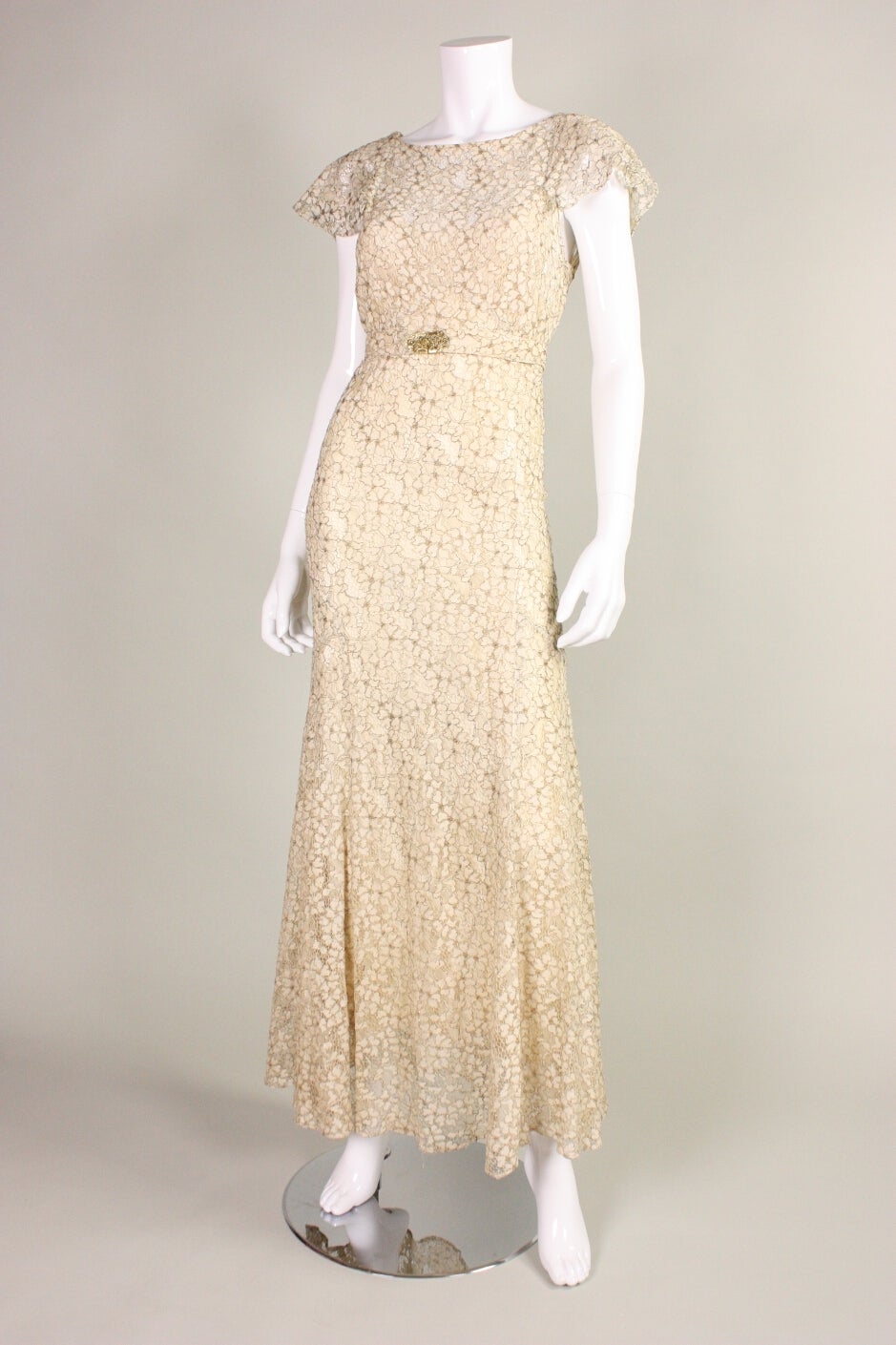 Vintage gown dates to the 1930's and is made of metallic lamé ivory lace in a floral pattern.  It is cut on the bias for that timeless 1930's silhouette.  Flounce sleeves.  V-neck back.  Side snap closures.  Unlined, but comes with an ivory silk
