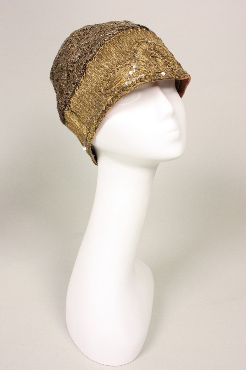 Vintage cloche dates to the 1920's and is made of gold lace and bullion that is highlighted with sequins.  Lined.