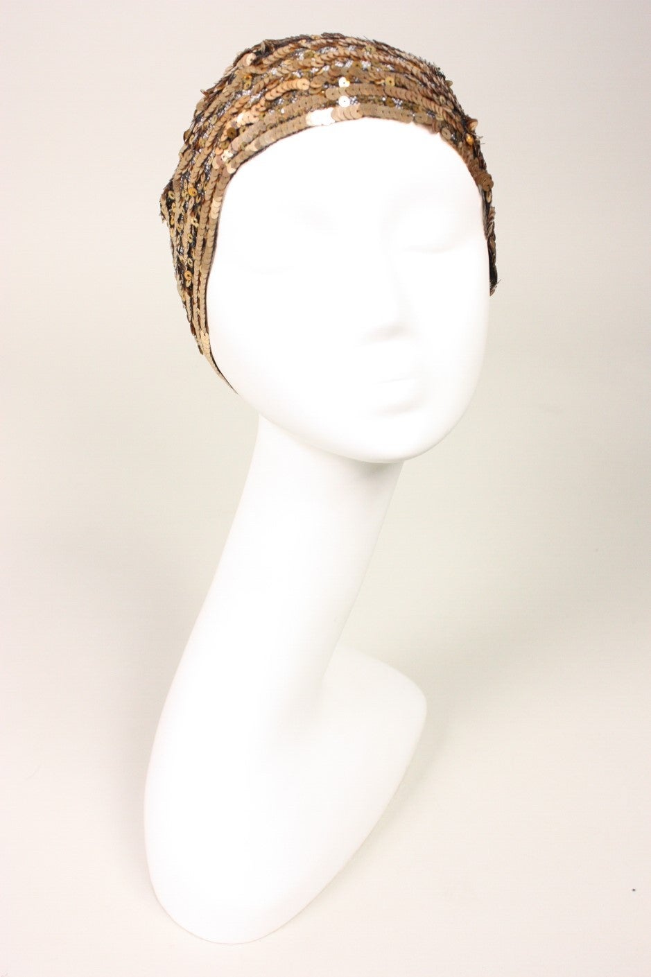 Gorgeous skull cap dates to the 1930's during the Art Deco period.  It is made of black netting that is covered with rows of copper-colored sequins.  Unlined.

Circumference: 22.5