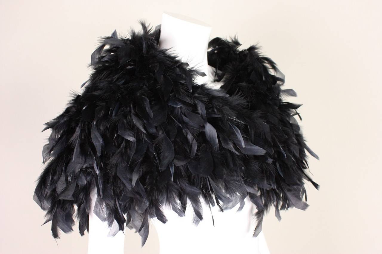 Vintage shrug is made of black feathers, likely turkey, and dates to the 1970's-1980's.  It is lined and has a center front hook and eye closure.  Synthetic lining.

Measurements-

Center Back Length: 14