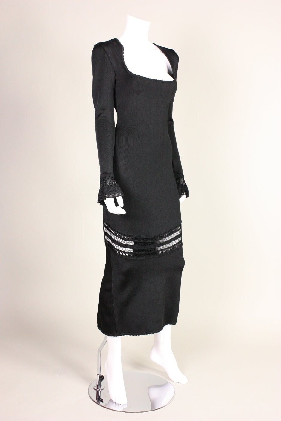 Jet black long dress with open lace knit panel from Azzedine Alaia dates to the 1990's. It features a scoop neck with picot trim and bell cuffs.  Unlined except for in the bust.  Made in Italy. Zips up center back with a hidden zipper.

Labeled