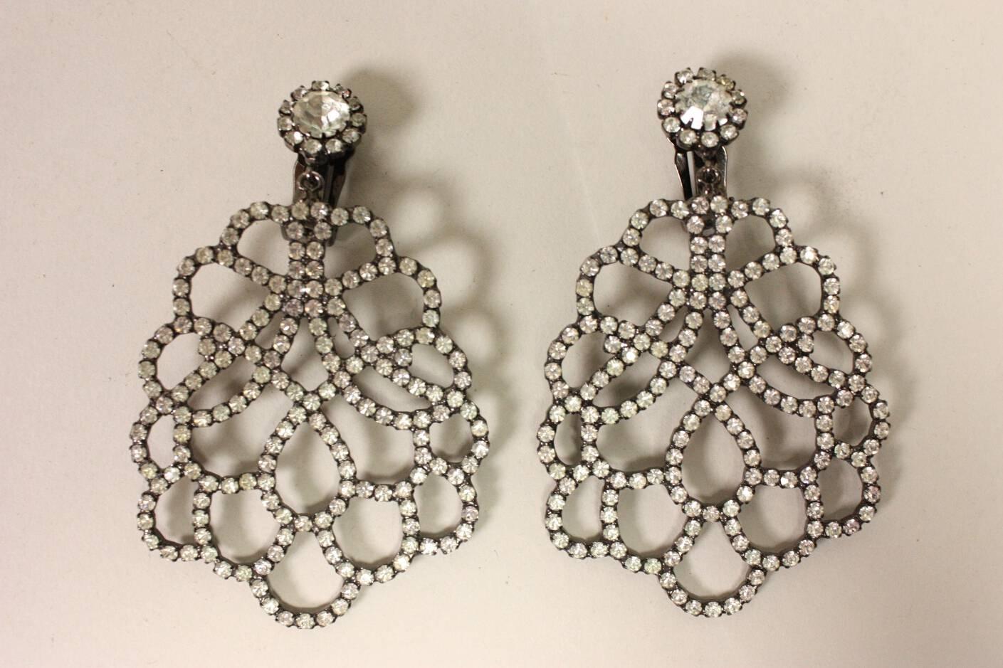 Vintage earrings from Kenneth Jay Lane likely date to the 1980's and are made of darkened silver-toned metal.  They feature clear rhinestones that are pave-set in a lattice pattern.  Clip backs. 

Earring measures 3.25