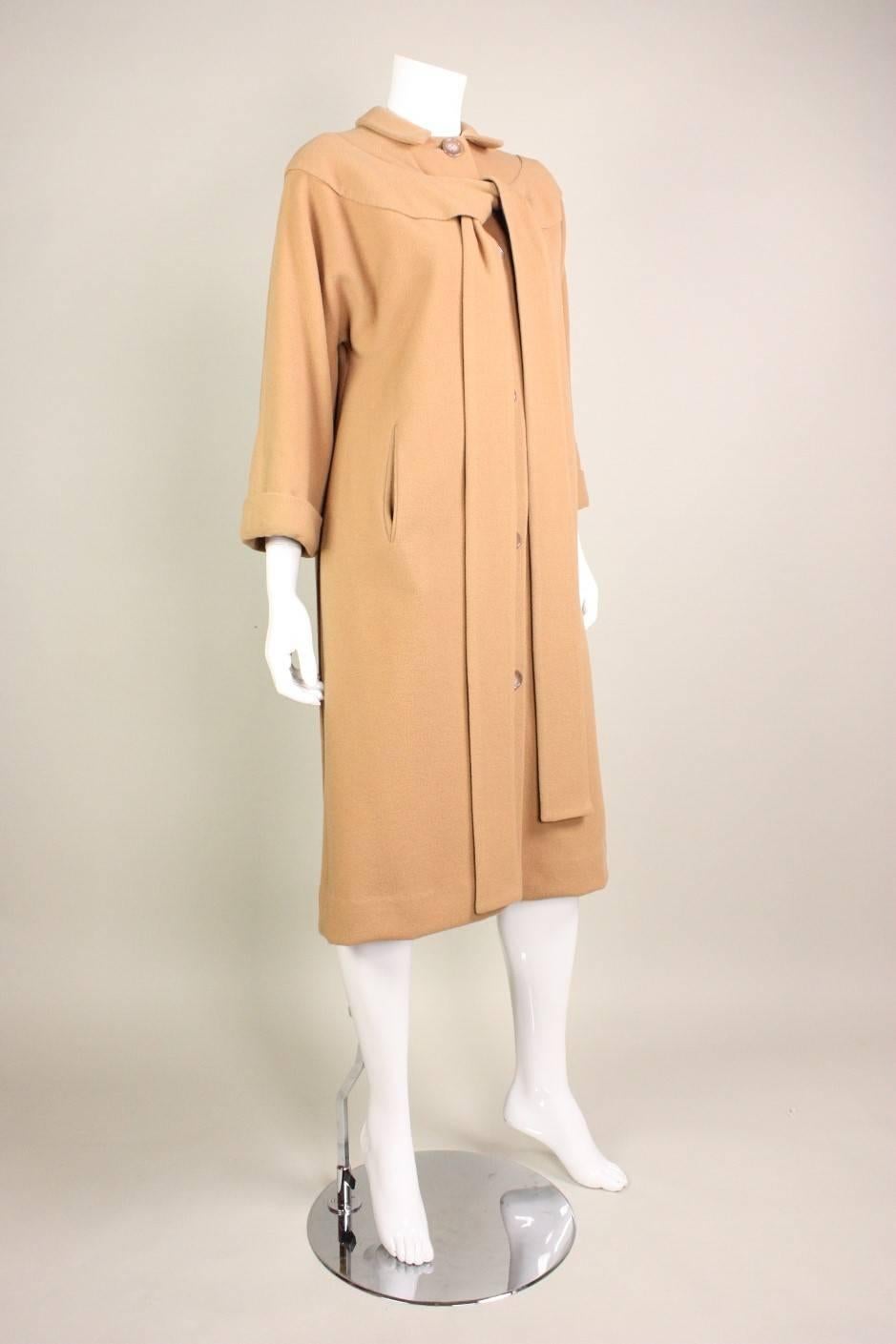 Vintage coat from Rudi Gernreich for Walter Bass dates to the 1950's and is made of camel-colored, double-faced wool.  Single-breasted with center front button closure.  3/4-length sleeves.  Interesting tie detail at bust.

Best suited for a size