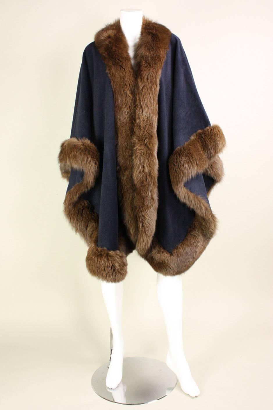 Vintage cape from Bergdorf Goodman is made of soft navy medium-weight wool with luxurious fur trim along all edges.  No closures.  Unlined. 

Free size.

Center Back Length: 39"