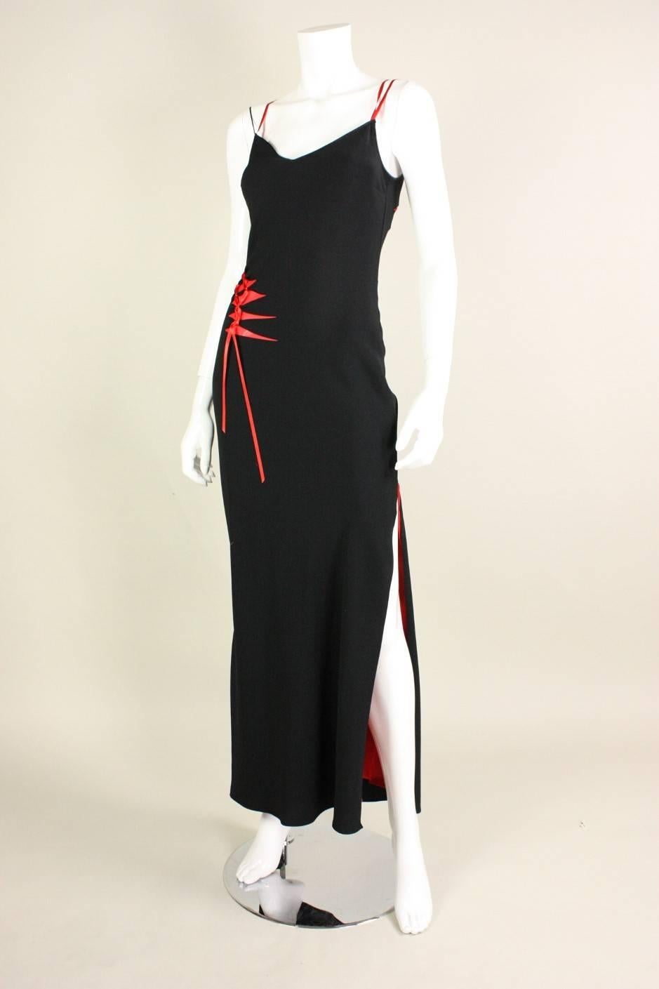 Bias-cut dress from John Galliano dates to the 1990's through the 2000's.  It is made of soft black polyester with a red silk chiffon lining that is exposed through angular cut-outs.  Dramatic side slit.  No closures.

Labeled FR 40/ US 6.  Please