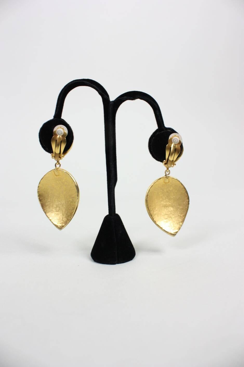 Vintage earrings from Karl Lagerfeld likely date to the 1980's and are made of gold-toned metal.  Clip backs.

Measurements

Overall Length: 2 3/4