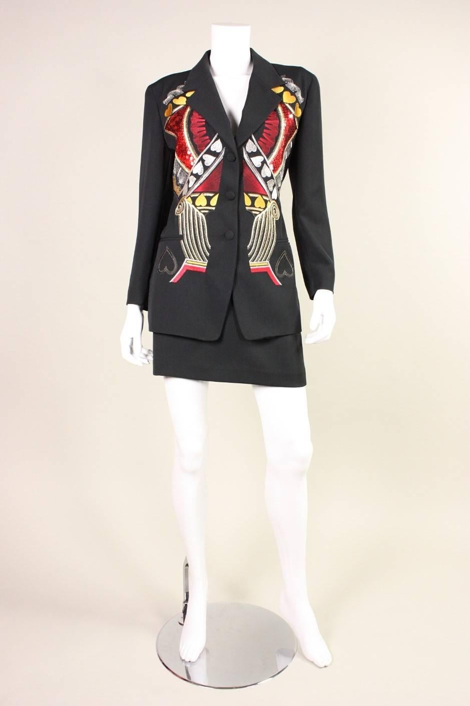 Vintage suit from Iceberg dates to the 1990's and features bold embellishment on the front of the jacket.  Single-breasted jacket has a notch lapel, padded shoulders, and three button closures.  Straight skirt has a side zipper and button at