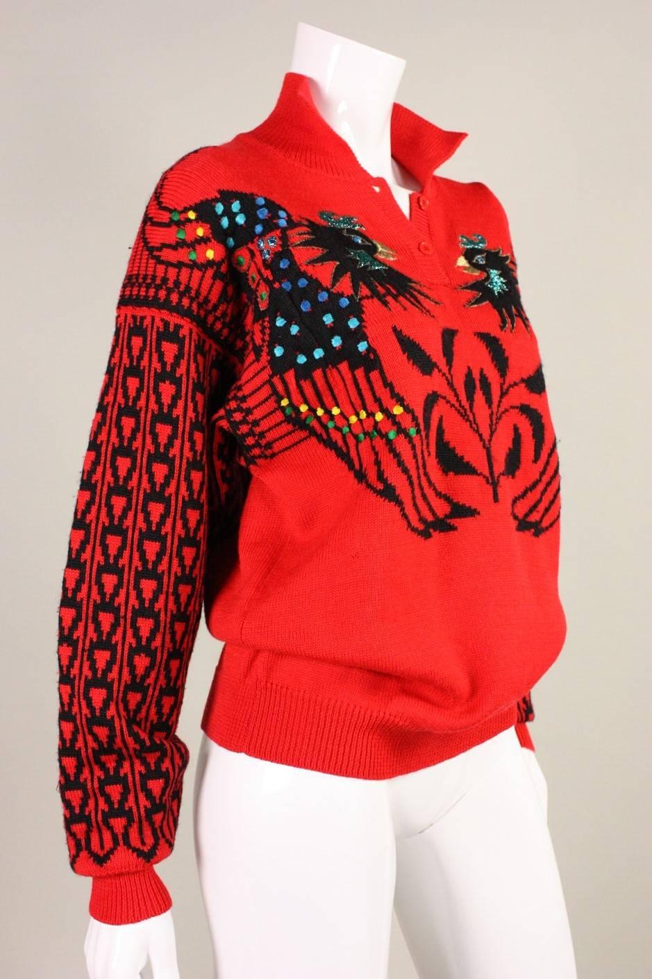 Vintage sweater from Kansai Yamamoto dates to the 1980's and is made of a red wool or wool blend.  It depicts phoenix birds that are decorated with multicolored embroidery.  Two button closure at neck.  Unlined.

No size