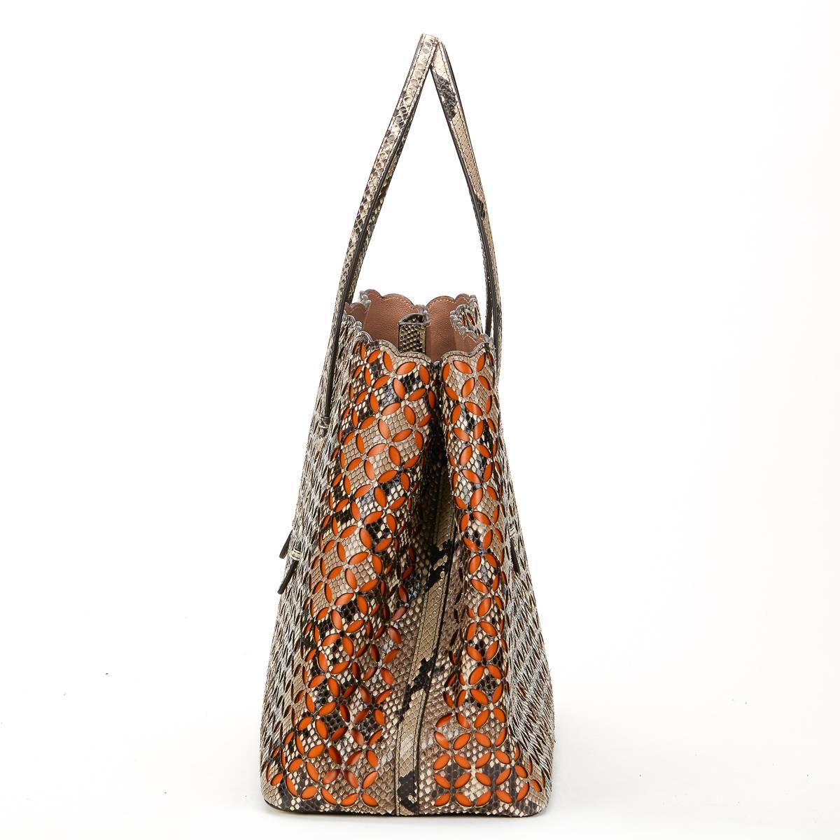ALAIA
Python Leather & Orange Calfskin Leather Perforated Shopper

Reference: HB576
Age (Circa): 2001
Accompanied By: Mirror, Interior Pouch
Authenticity Details: (Made in Italy)
Gender: Ladies
Type: Shoulder, Tote, Shopper

Colour: