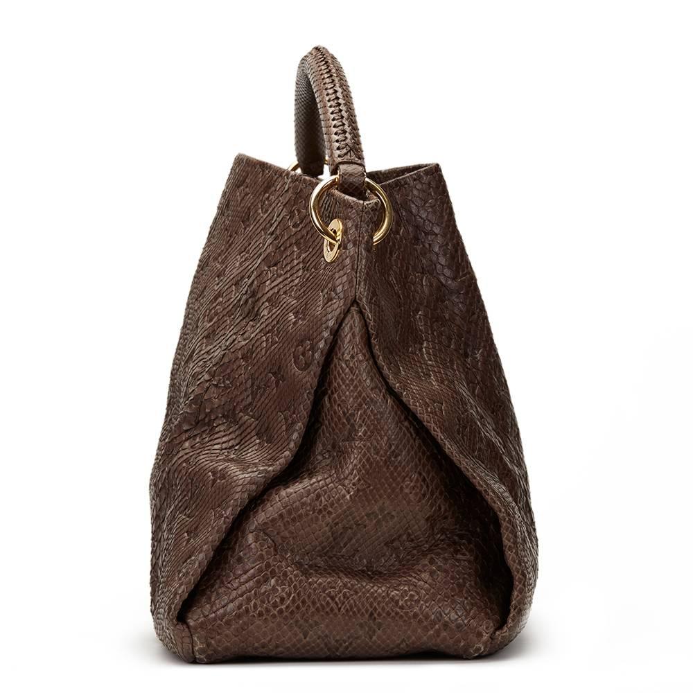 LOUIS VUITTON
Gris Python Embossed Monogram Artsy MM

This LOUIS VUITTON Artsy MM is in Excellent Pre-Owned Condition. Circa 2010. Primarily made from Python complimented by Golden Brass hardware. Our  reference is HB1141 should you need to quote