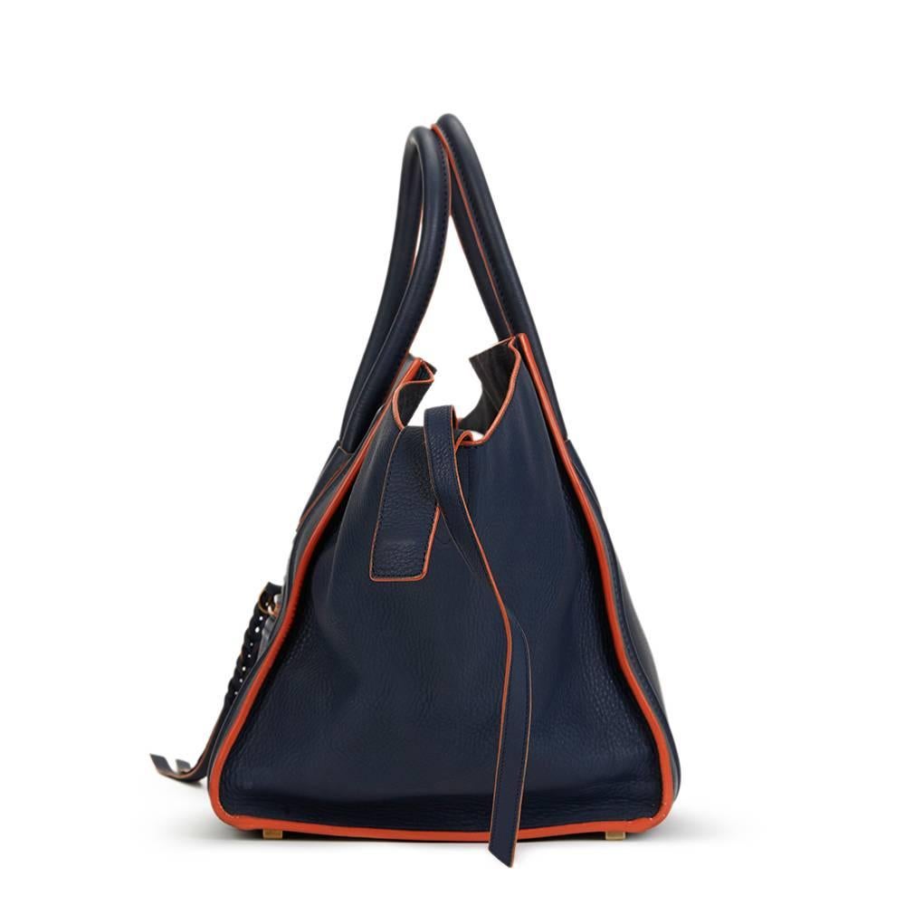 CELINE
Navy Supple Calfskin Leather Orange Trim Medium Phantom Luggage Tote

This CELINE Medium Phantom Luggage Tote is in Excellent Pre-Owned Condition. Circa 2012. Primarily made from Supple Calfskin Leather complimented by Aged Gold hardware. Our