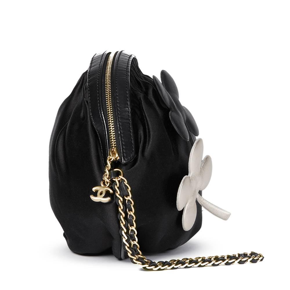 "CHANEL
Black Satin Four Leaf Clover Timeless Wristlet Clutch

This CHANEL Timeless Wristlet is in Very Good Pre-Owned Condition accompanied by Chanel Dust Bag. Circa 2004. Primarily made from Satin complimented by Matte Gold hardware. Our 