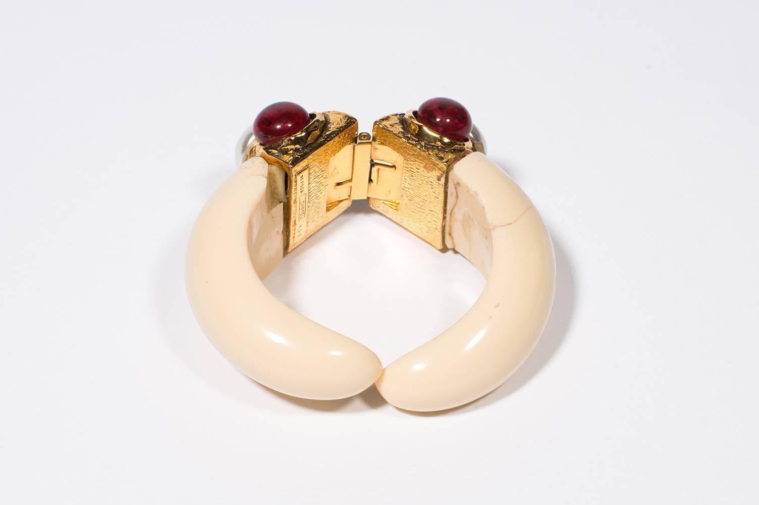 1970's  Rare Chanel Cream Bracelet Fake Pearl, Red Cabochon
Amazing Bracelet in cream resin  . The mecanism is a gold metal spring that holds within it the double C C   . On each side you have 2 red glass cabochon and a fake pearl  . This piece is