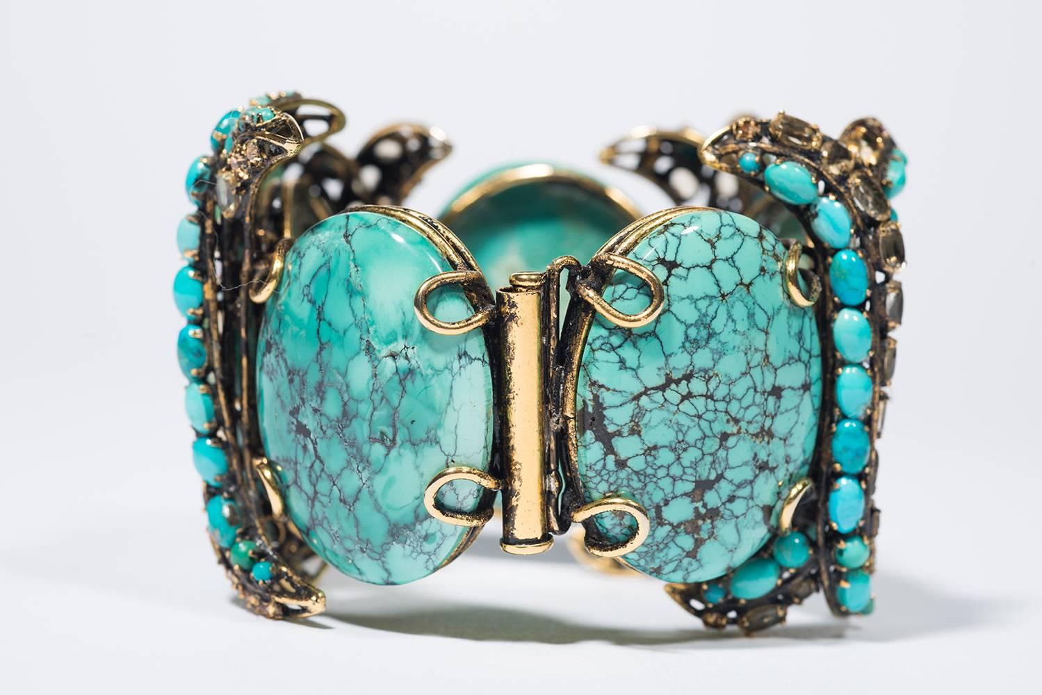 1990s Stunning Iradj Moini Vintage Fake Turquoise Cuff

Iradj Moini is a very famous jewels designer known for matching colors, stones and rhinestones. This amazing cuff is made of five big oval fake turquoise linked by two curves : one of fake