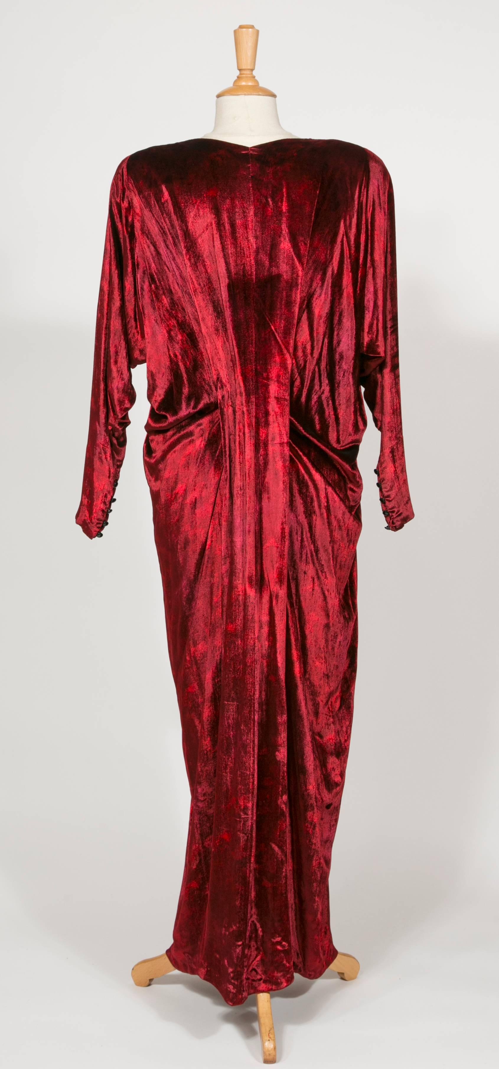 1975 Yves Saint Laurent Haute Couture Iconic  Ruby Silk Velvet  Evening Dress
This stunning long dress : Oriental inspiration with kimono long sleeves 5 black buttons on the wrist . One big black velvet flower on the V  décolleté.
A very long shawl