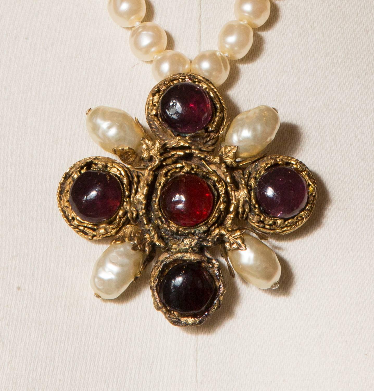 1984 Chanel by Gripoix Rare Necklace Fake Pearls and Cross Pendant .
Fabulous and rare necklace barocco faux  38 pearls with a cross pendant with 4 oval fake pearls and 5 glass cabochons one red ruby and four like amethyst
The pendant is signed and