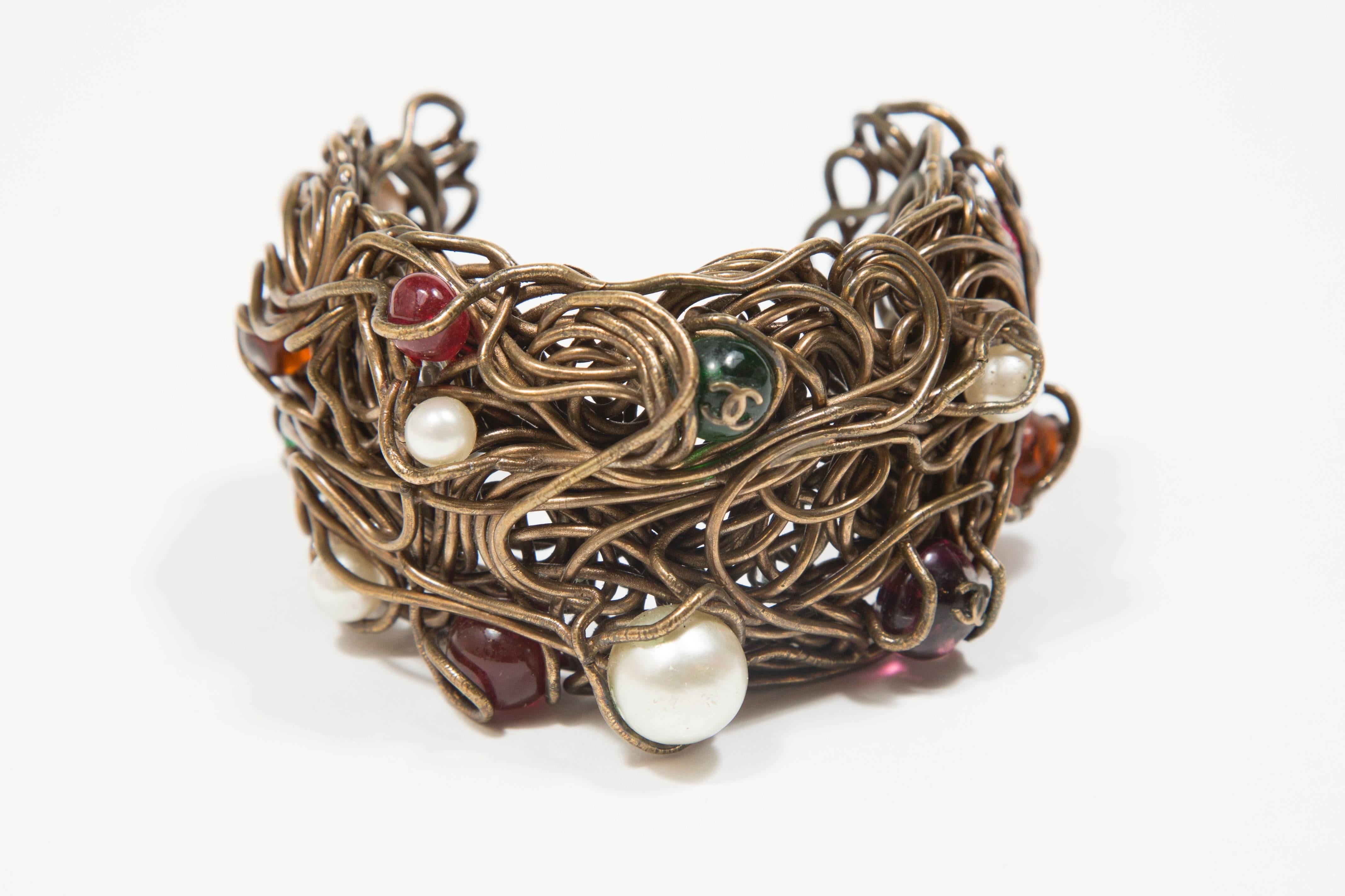 1997/98 Chanel Fabulous Cuff Bronze Fake Pearls And Glass Pearls .
This stunning cuff is in bronze  interweaved wire with inside like a nest fake pearls fake ruby  pearls fake emerald pearls  signed double CC 
and signed inside 