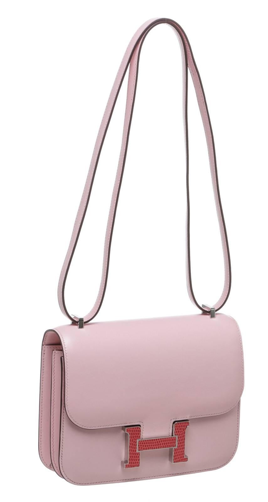 Show off your signature style with this gorgeous Hermes handbag! This Constance bag is constructed from pink leather with an exotic lizard H buckle along the front. Open the flap to reveal a spacious interior for your valuables! 