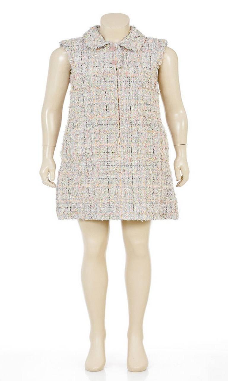 This fun and flirty sleeveless dress features a chunky knit construction with a blend of cotton, nylon, and acrylic. It has a unique multicolor windowpane print pattern and a babydoll collar. The dress has a zip up front and buttons at the neck with