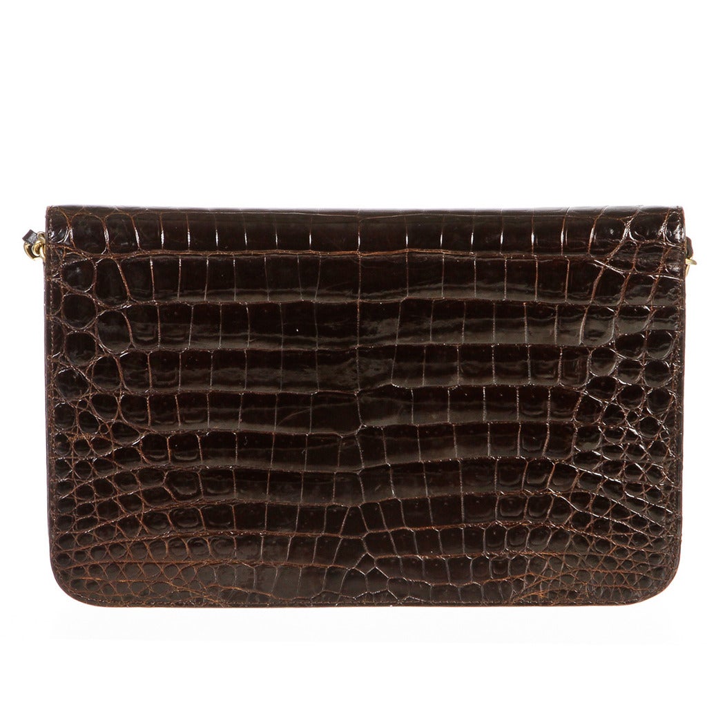 If you're looking for the ideal bag that can transition from day to evening, then this vintage shoulder bag from Chanel is the perfect one! It comes in a brown crocodile. It closes with a single flap style and secures with push pin closure in the