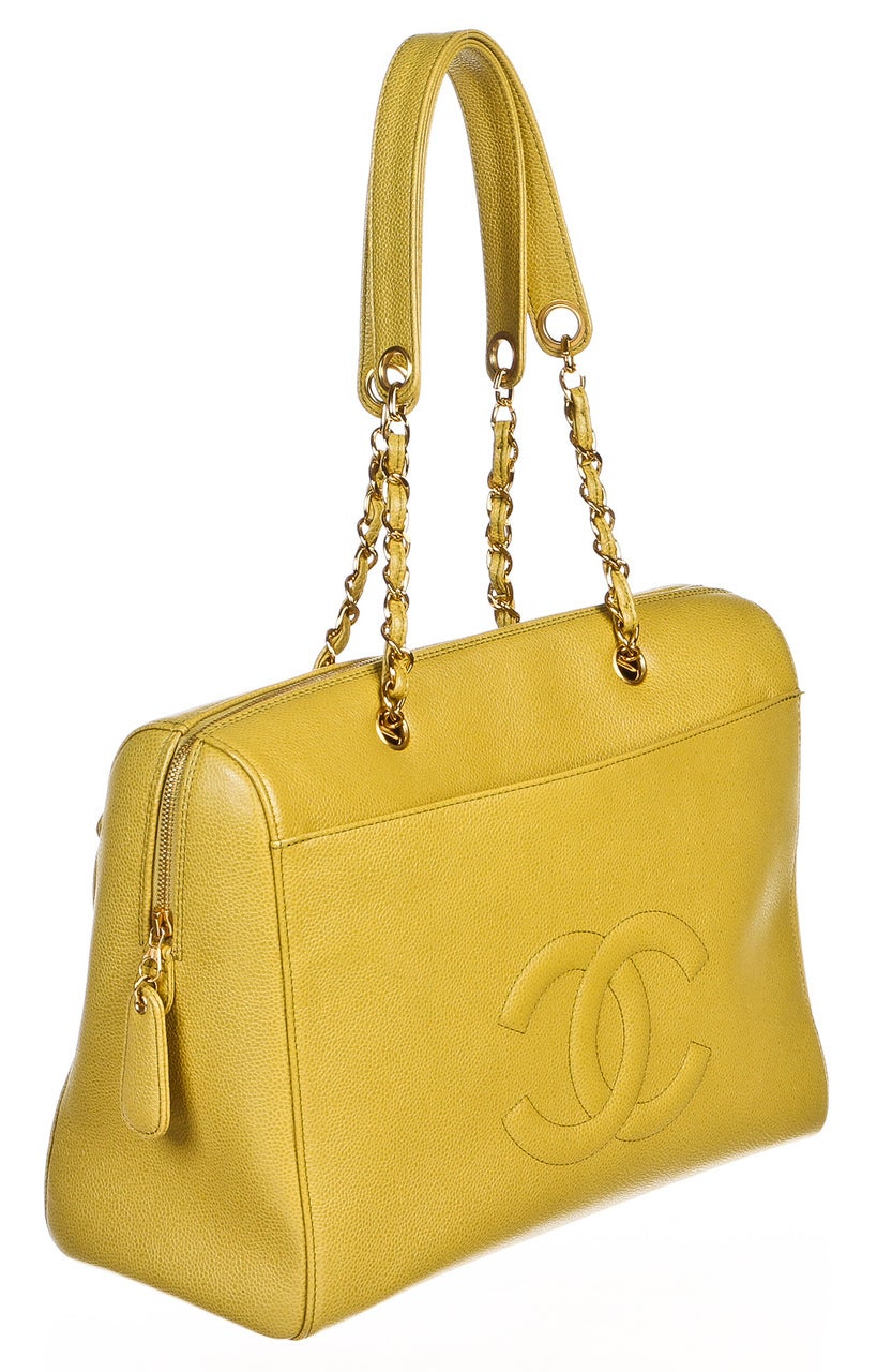 Featured here at Onquestyle is this ultra chic handbag from Chanel. Crafted from lime green leather, this bag features gorgeous gold tone hardware. A stitched CC sits on the exterior. Inside the top zipper, you will find matching lining and a single