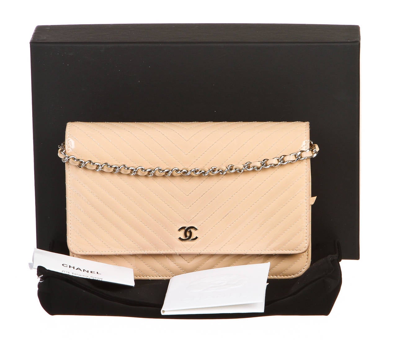 Show off your inner fashionista with a stunning Wallet on Chain crossbody from Chanel! It closes in a flap style as a CC rests in the front atop the snap closure. A chain link strap weaves a beige chevron patent leather that is also found in the