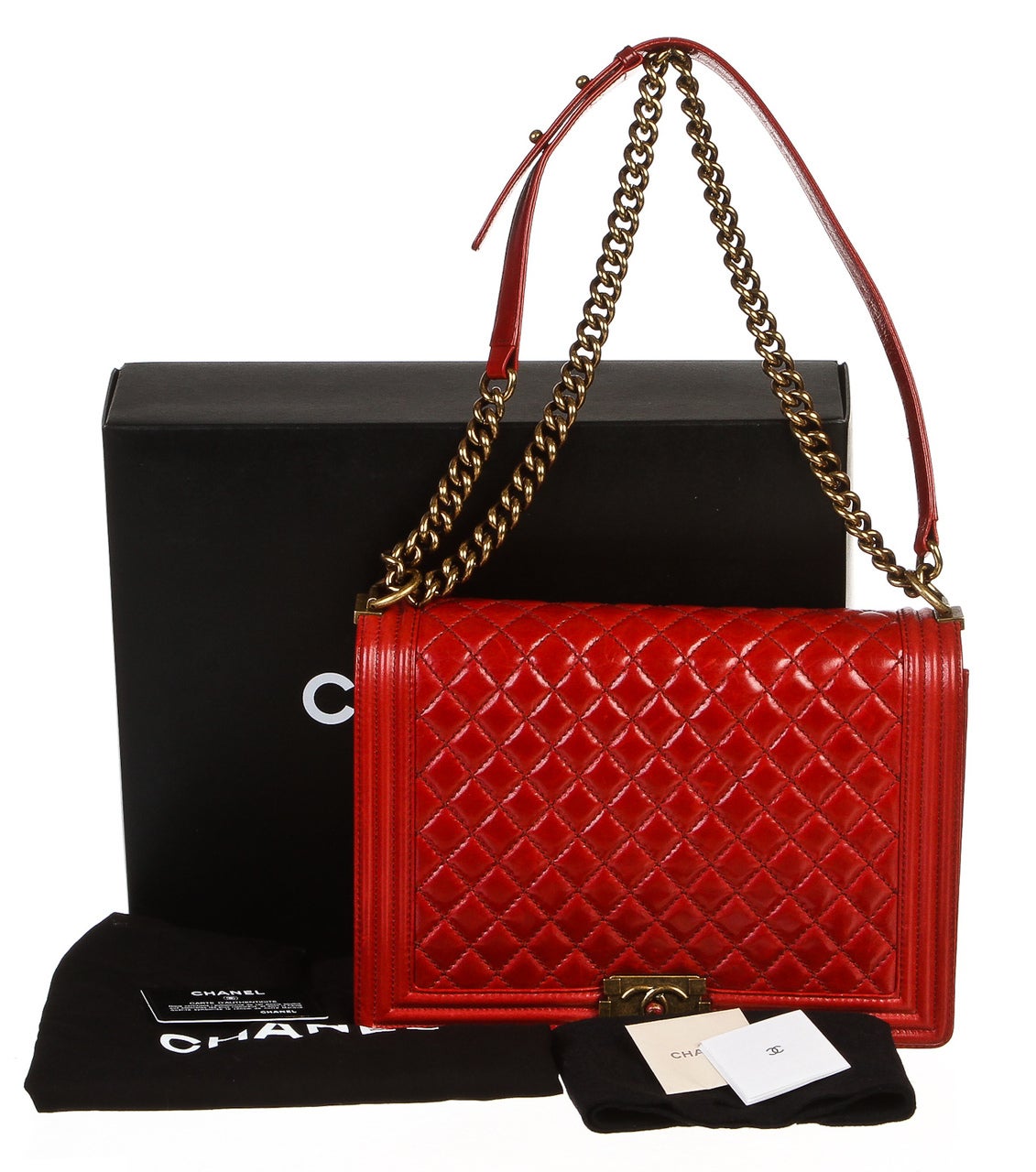 Add a shimmering statement to your style with this vivacious red lambskin Boy Bag from Chanel! This one-of-a-kind flap bag features an quilted stitching that arches from the front to the back as gold-tone hardware moves throughout the chain handle.