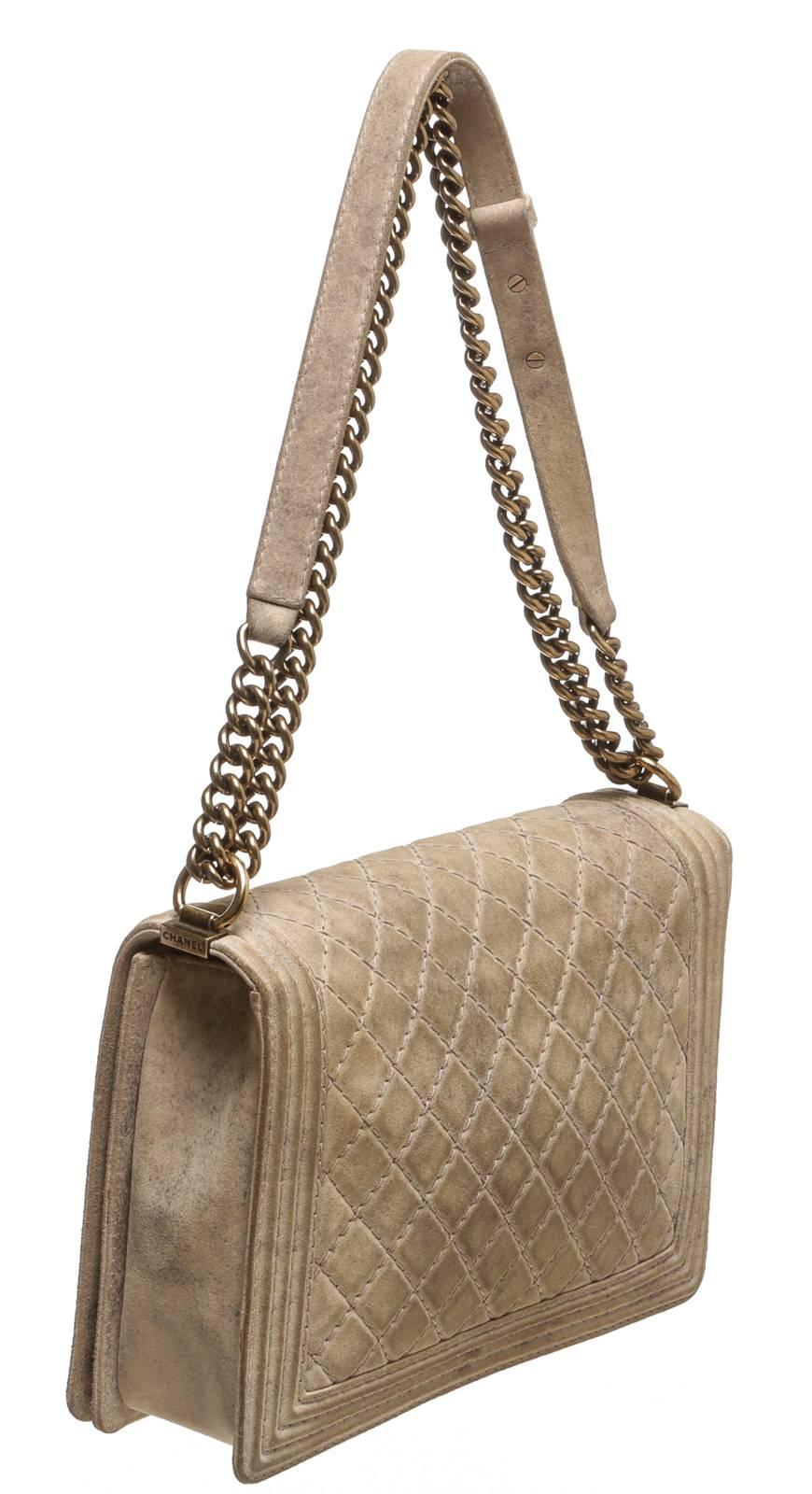 Add a stunning statement to your style with this Large Boy Bag! This one-of-a-kind flap bag features a quilted leather that arches from the front to the back as aged gold-tone hardware moves throughout the chain handle. A leather strap contrasts as