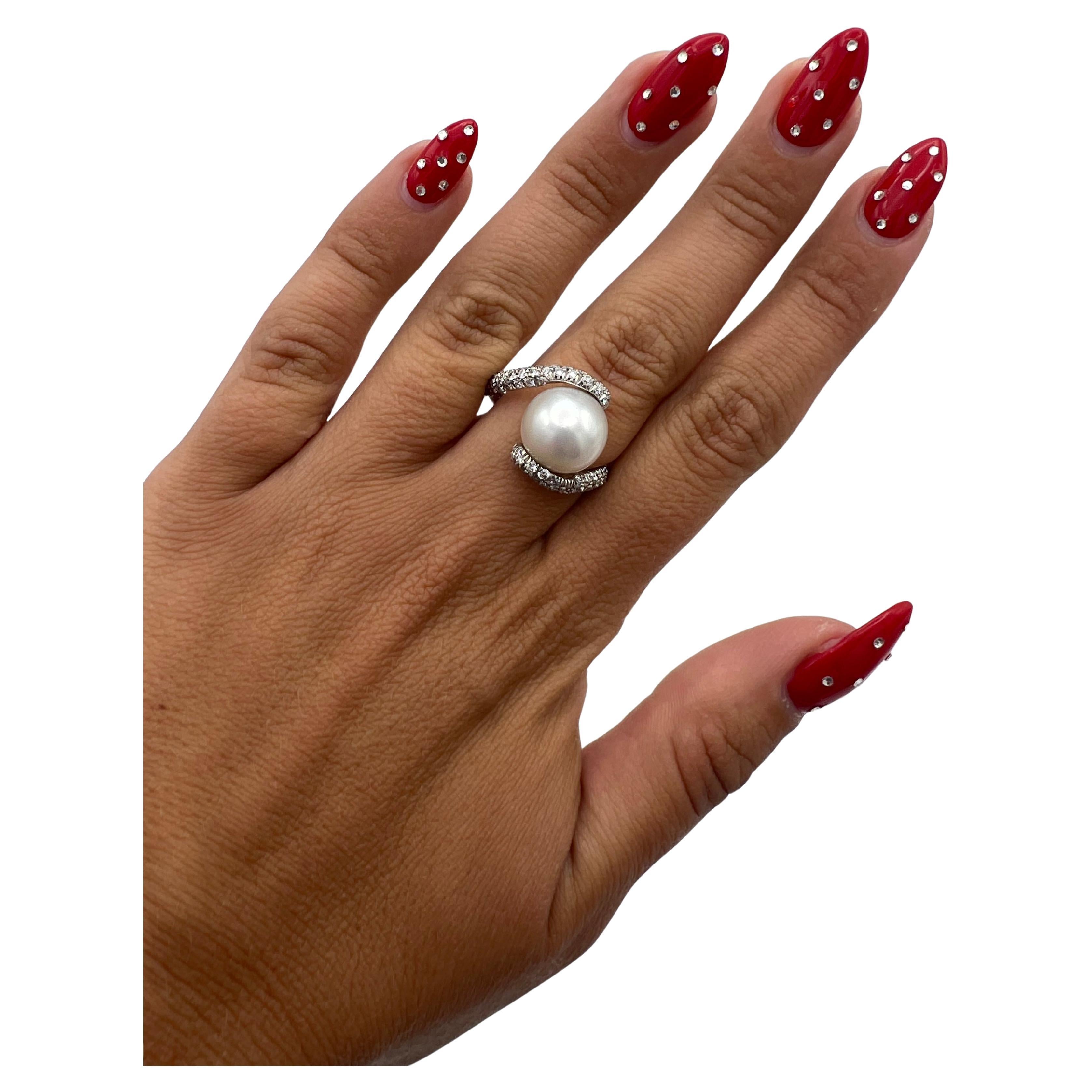 The ring features white cultured pearl, approx. 11.5mm, accented with 0.68 carats of round brilliant cut diamonds around it and set in 18k white gold.
Band width is 2.4 mm.
Ring size is 7.25.
Total weight is 8.1 grams.
Hallmarks: 750 and M for