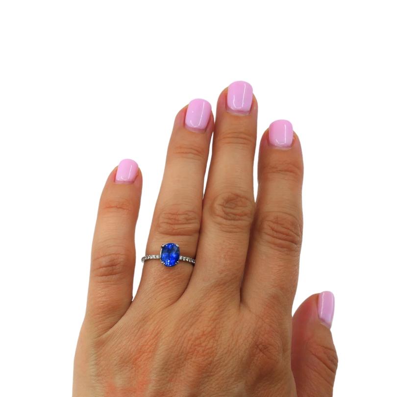 Im Mittelpunkt dieses eleganten Rings steht ein blauer Saphir im Ovalschliff, der sicher in einer klassischen Vier-Zacken-Fassung aus Platin (Pt950) gefasst ist. Das Band ist zierlich mit einer Reihe von  runde Diamanten im Brillantschliff, die für