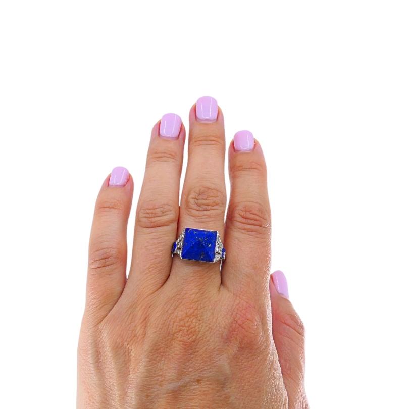Questo autentico anello Cartier del periodo Art Déco presenta un audace lapislazzuli accentato da diamanti rotondi a taglio brillante. Il centro è costituito da un sorprendente lapislazzuli tagliato a forma di pan di zucca, rinomato per la sua