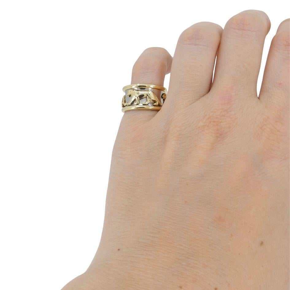 Cette bague vintage Panthère de Cartier est réalisée en or jaune 18 carats et en acier inoxydable. Le design présente une panthère sculptée en or marchant le long de la bande d'acier. La bande audacieuse mesure 1,5 cm de large et correspond à une
