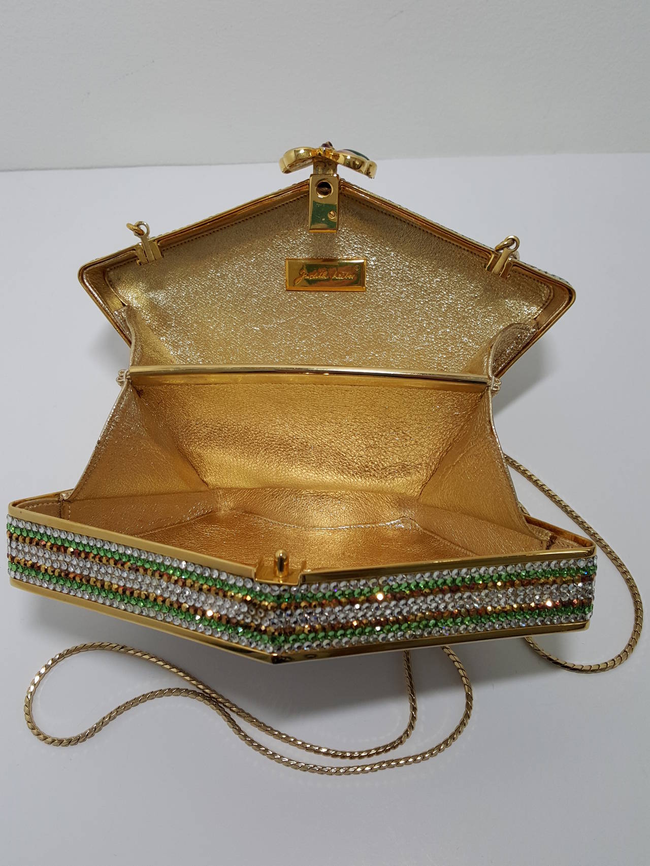 This beautiful Judith Leiber Swarovski crystal minaudiere with multi colored butterflies is a must for any collection.  It has the appearance of never been carried.  The gold tone chain can be stored inside the bag to carry as a clutch or extended