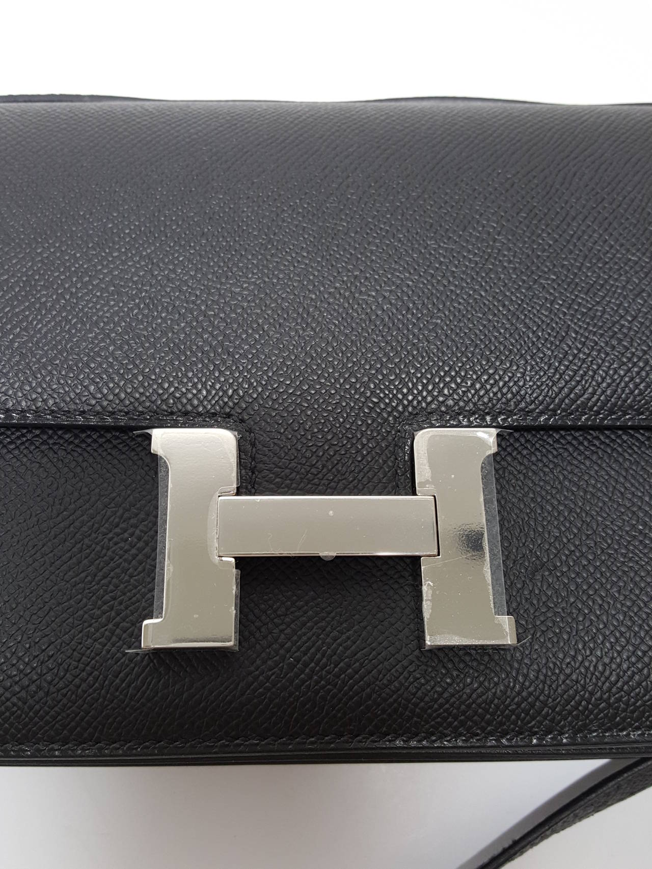 Here is a lovely HERMES Constance Elan 25 cm in black Epsom leather with palladium hardware.  Never used.  Plastic is still on the hardware.
The lovely and durable Epson Leather is less likely to show wear and scratches.  This piece will arrive to
