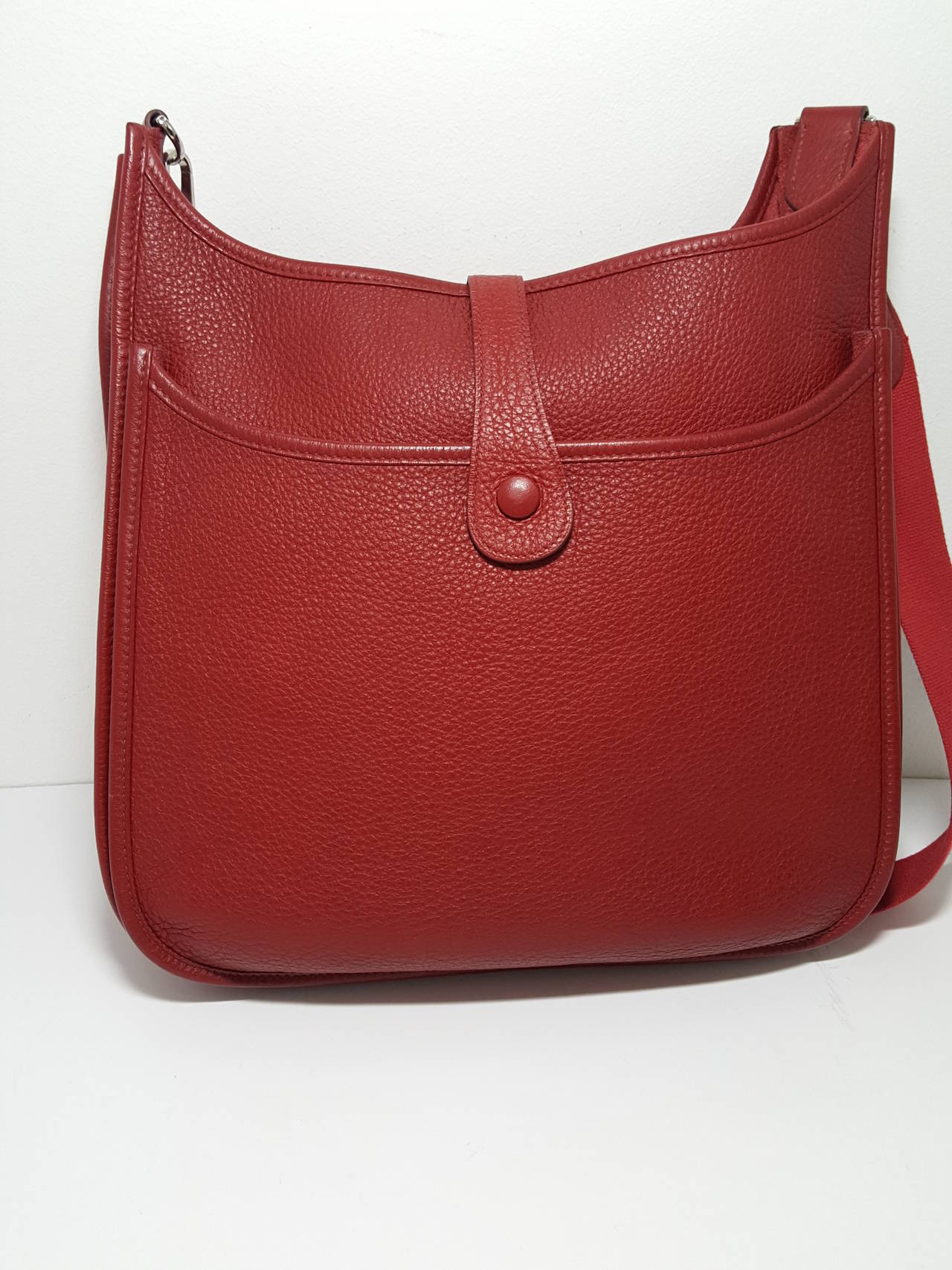 Here is the perfect shoulder/cross body bag by HERMES.  It is the Evelyn II GM in fabulous rouge Clements leather.  This one is sold with an additional matching Hermes Leather tassel, too. The strap hardware is palladium. The bag was only worn once