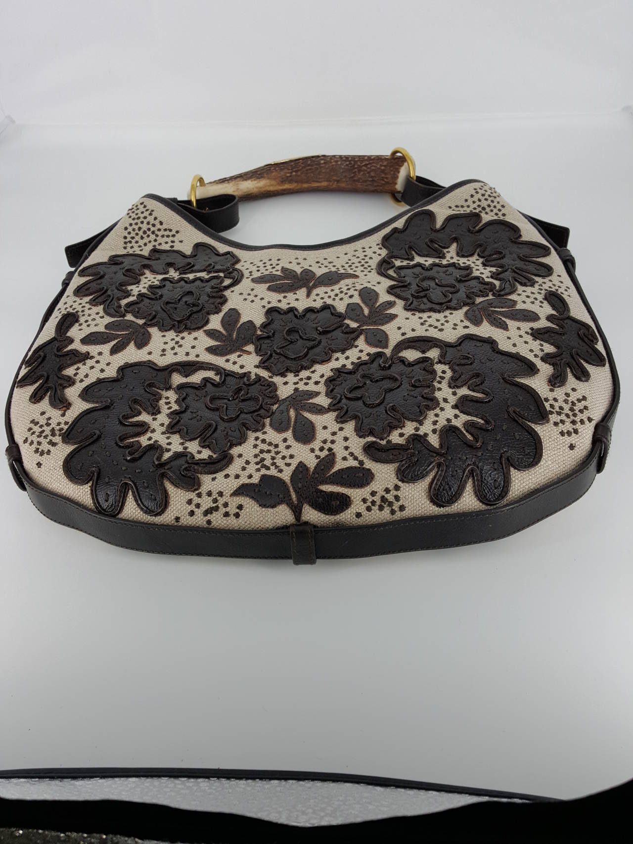 This is a unique edition of YSL's Rive Gauche Mambasa Bags.  This Fabric bag with leather leaves and horn handle is available for sale.  This handbag was never used and in excellent condition.  The stunning horn handle makes a
