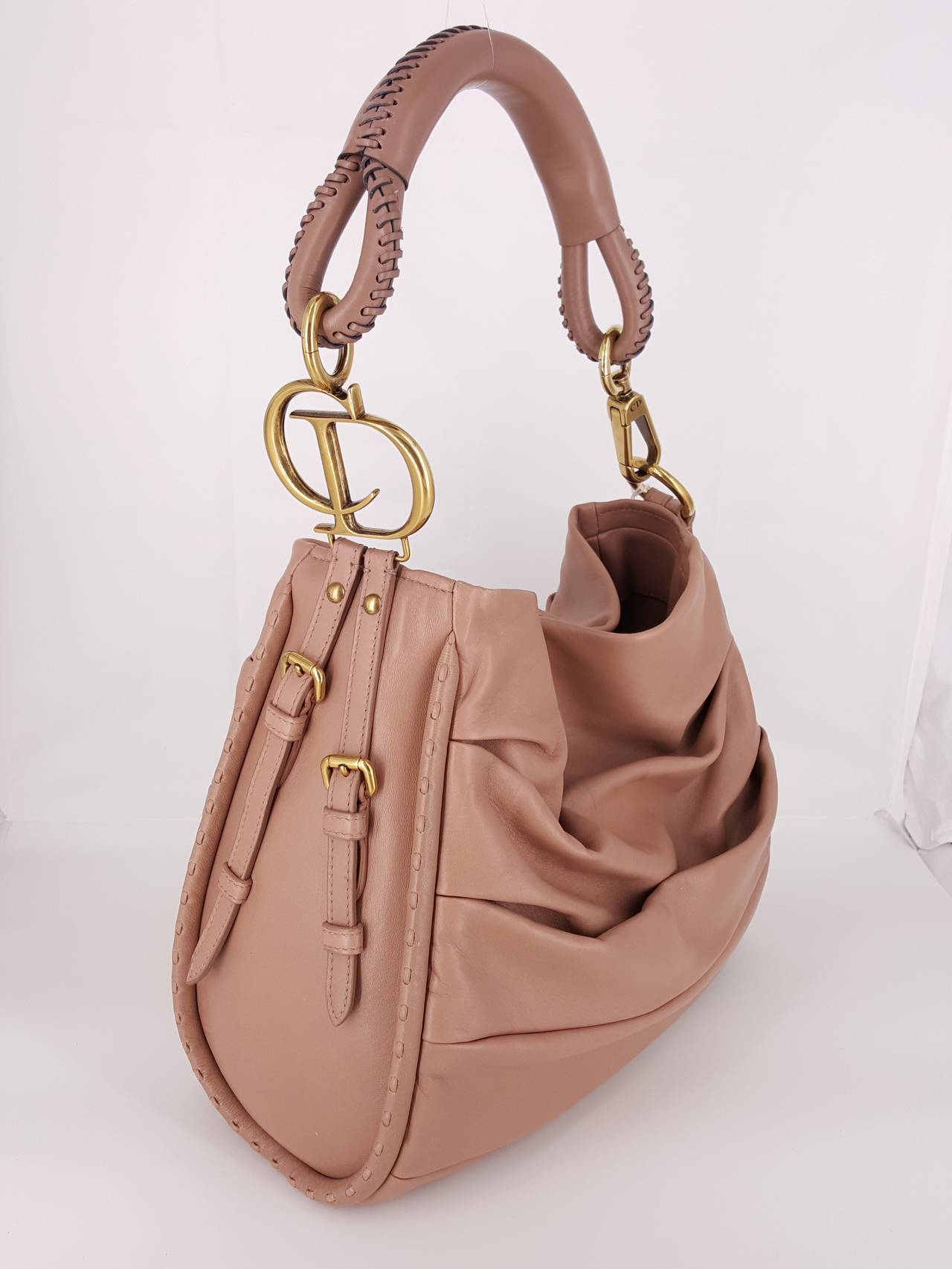 Here is a fabulous, never worn Dior Libertine Hobo.  The leather is soft and supple and the color is a nude.   The detail on the handle is stunning and is accentuated with a large brush gold CD on one side.  This never worn beauty has a timeless