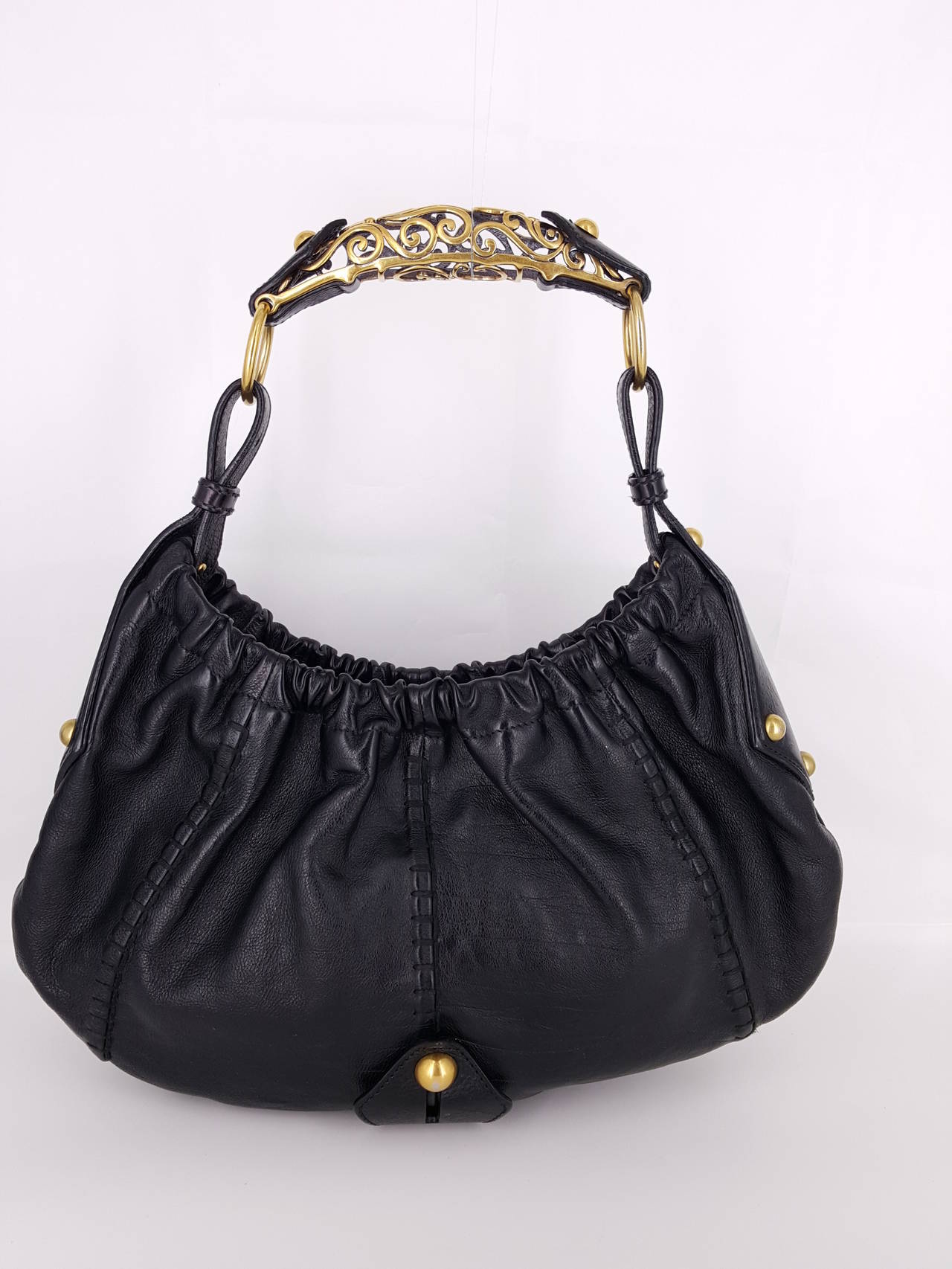 Offered for sale is this YSL Black Leather Mombasa hobo bag from the Rive Gauche collection with beautiful open work gold horn. Designed by Tom Ford, these handbags remain collectible.
This one has a change purse attached.

  The interior is